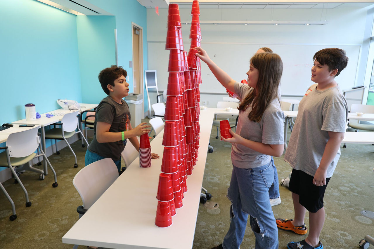 Children stacking red cups