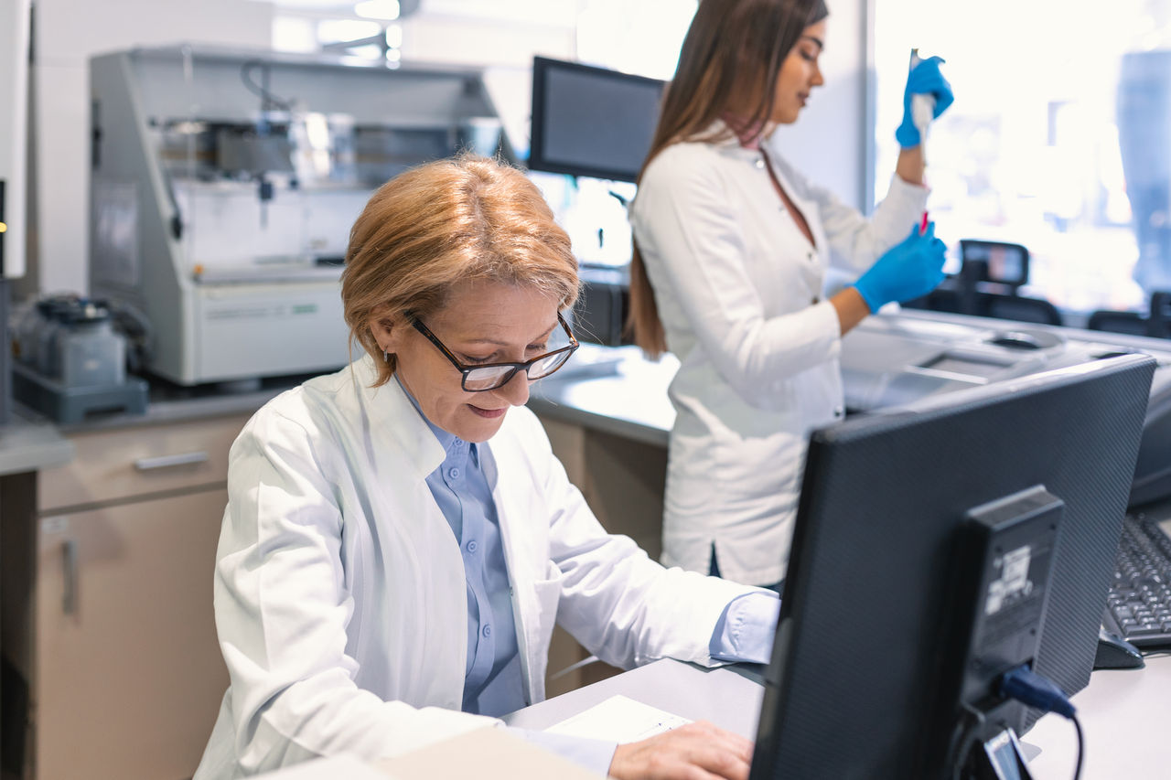 Doctor on computer & lab tech