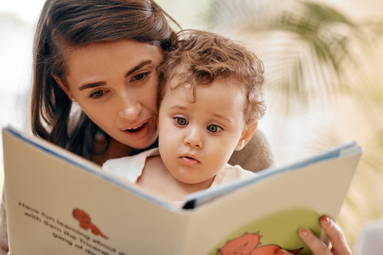 A mother reads to her attentive child.