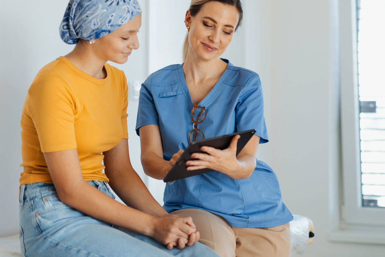 A nurse reviewing notes with a female teenager