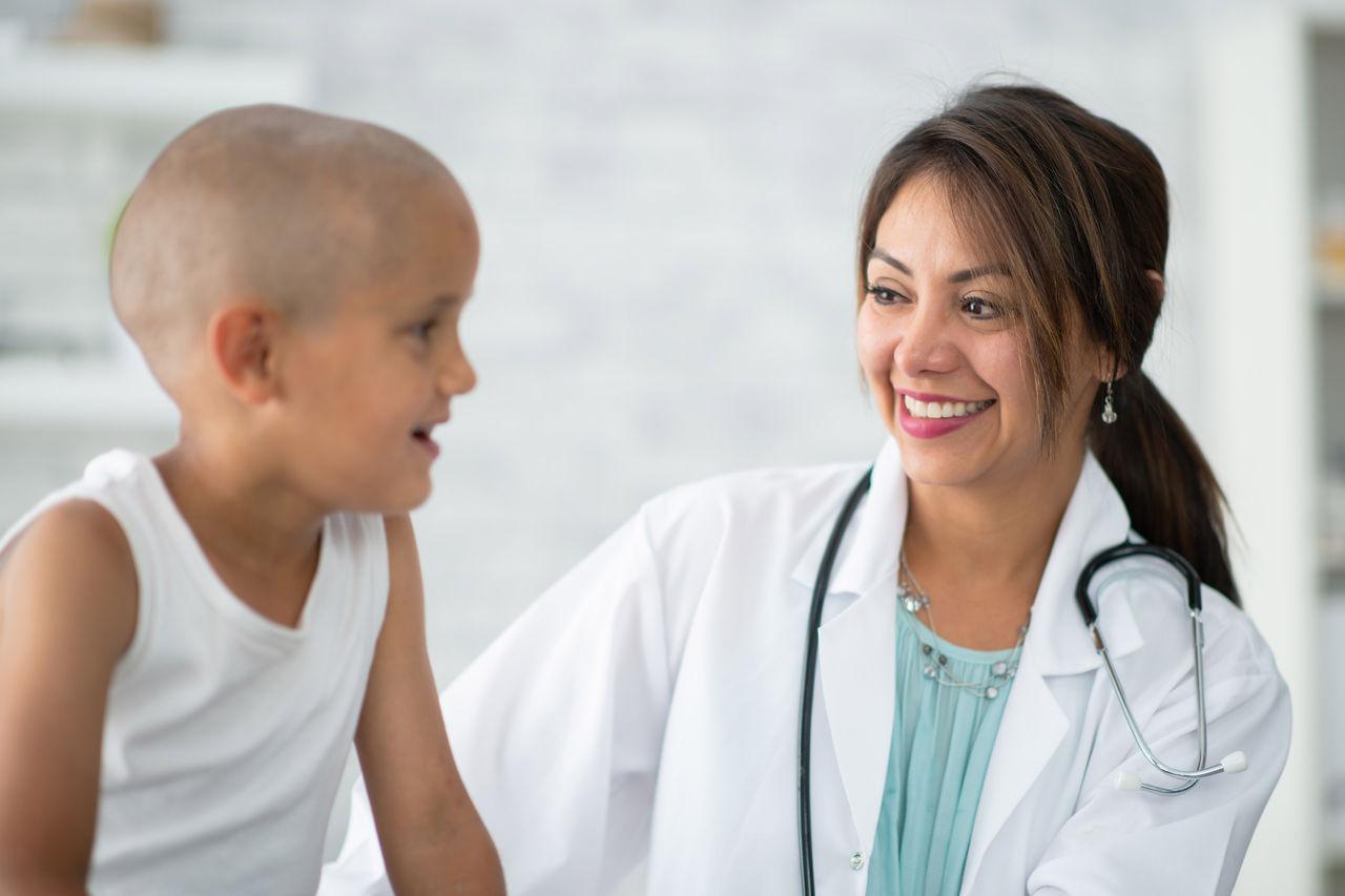 Female doctor talking to a young boy on an examination table