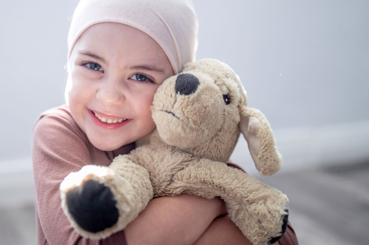 Close up of a young girl hugging a stuffed dog