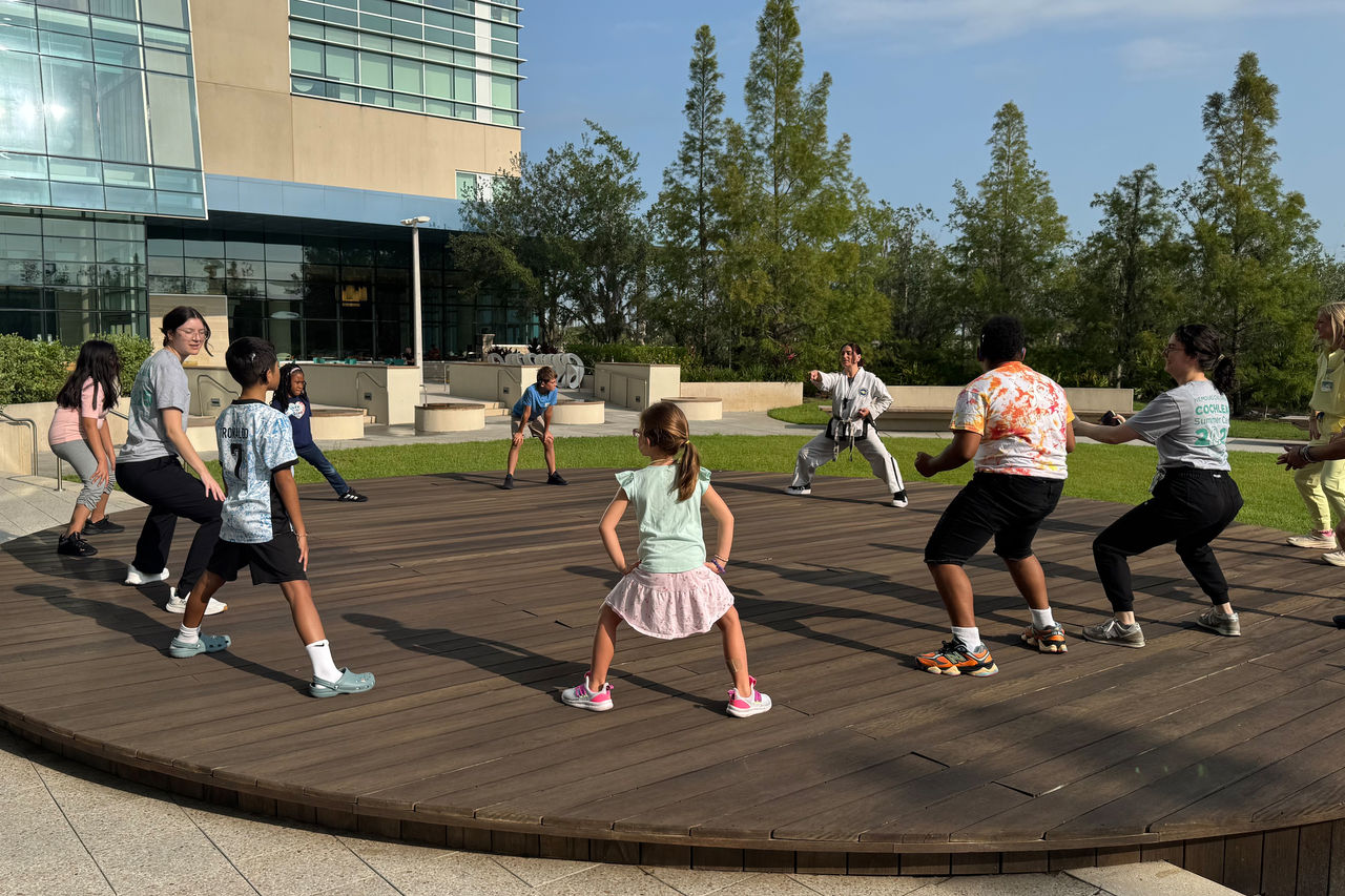 Group of children at cochlear implant summer camp participating in a martial arts demonstration