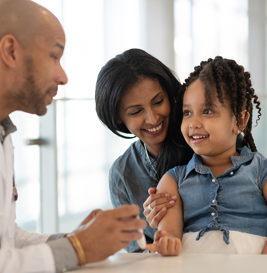 A doctor making a mother and daughter smile. 