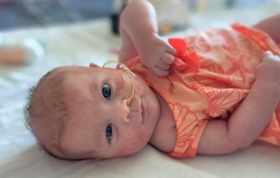 Photo of baby Lulu wearing an orange dress.