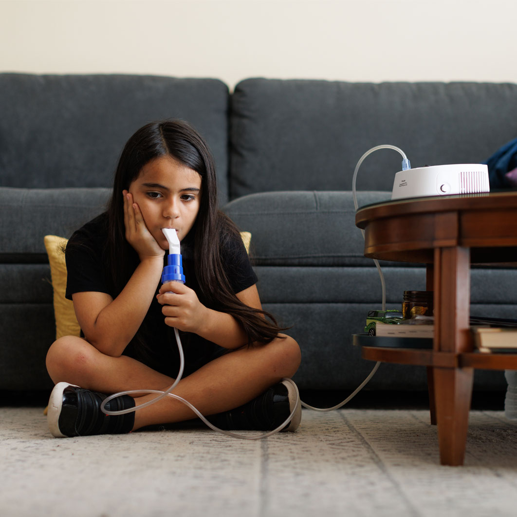 Girl with nebulizer at home